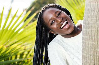 Glad african teenager with braids.